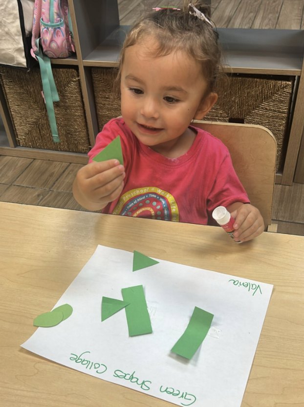 Niña haciendo un collage de figuras verdes