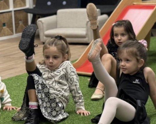 Niñas estirando la pierna en clase de movimiento