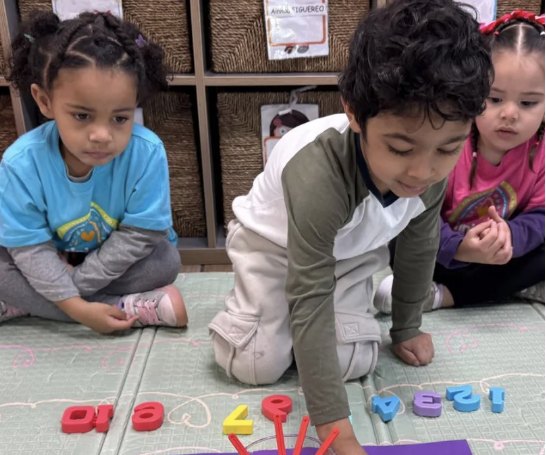 Niño concentrado contando popotes junto a números de colores