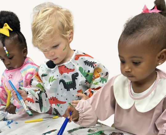 Niños pintando con pinceles en la clase de arte